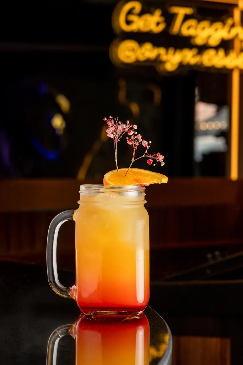 Tall orange cocktail at the bar